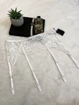 Portaligas blanco de encaje elastizado con ligas ajustables.