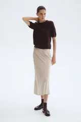 Buzo de punto fino color marrón oscuro, con cuello redondo y mangas cortas. Presenta remates acanalados en cuello, puños y bajo.