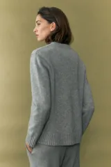 Cárdigan gris melange con cuello en V y cierre frontal con botones.