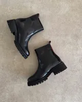 Botín de cuero color marrón con suela track negra y cierre lateral.