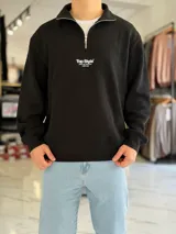 Buzo negro de cuello alto con cierre parcial y detalle de texto blanco estampado en el pecho "Top Style".