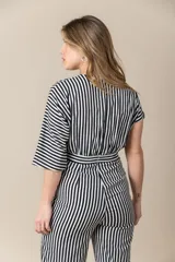 Mono largo a rayas verticales blancas y negras con mangas cortas asimétricas y cierre invisible en la espalda.