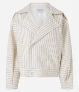 Tapado corto tipo trench coat confeccionado en sarga de algodón, de color beige con estampa de rayas finas verticales y horizontales. Presenta cuello solapa, mangas largas, bolsillos laterales con ribete y cierre frontal cruzado con doble botonadura.