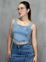 Top celeste de jean con breteles anchos y cierre frontal.