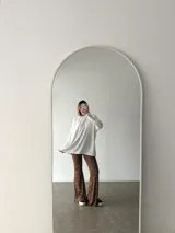 Conjunto de dos piezas compuesto por un buzo de cuello redondo y mangas largas con diseño holgado y un pantalón de corte recto y tiro alto. Ambas prendas están confeccionadas en tejido de punto acanalado.