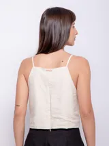 Top negro sin mangas con tirantes finos y escote cuadrado. Presenta una pequeña abertura en la parte delantera y cierre invisible en la espalda.