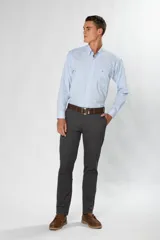 Pantalón de gabardina color marrón claro, corte slim fit, con bolsillos laterales y traseros. Se ajusta a la cintura con cinturón de cuero marrón.