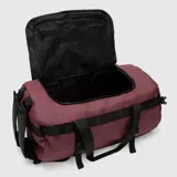 Bolso duffel de viaje color bordó con detalles en negro. Cuenta con correas de mano, correas ajustables, cierres reforzados y base resistente al agua.