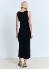 Vestido midi de punto fino color negro, sin mangas, con escote en V y detalle de apertura con lazo en el pecho.