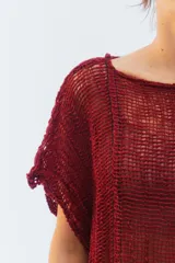 Remerón de algodón marrón con tejido de punto calado, escote redondo, hombros caídos y mangas cortas. Presenta un calce amplio, largo a mitad de muslo y ruedo con terminación desflecada.