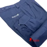 Pantalón de vestir verde oliva, de corte recto, con bolsillos laterales y traseros. Se ajusta a la cintura con cinturón de cuero marrón.