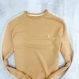 Buzo deportivo color naranja con mangas ranglan color crema y logo bordado en el pecho. Confeccionado en algodón.