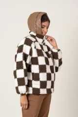 Campera símil corderito a cuadros marrones y blancos, con cierre frontal y bolsillos laterales. Capucha y bolsillo frontal con cierre de nylon color marrón.