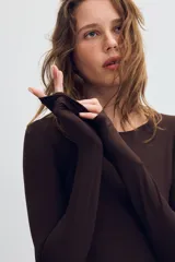 Body de poliamida con cuello redondo y manga larga. Presenta un diseño ajustado con cierre de botones a presión en la parte inferior.