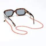 Correa para lentes de cuentas rojas semitransparentes con enganches dorados. Puede usarse como collar o sujetador de mascarillas.