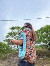 Chaleco tejido a mano con lana merino, de diseño multicolor con borde celeste.