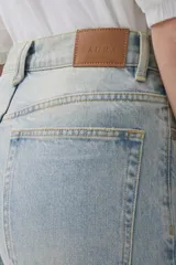 Jean celeste de calce recto, tiro medio-alto, lavado claro y ruedo desflecado.