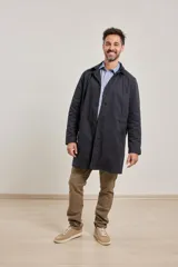 Gabardina color beige de algodón, con cuello clásico, cierre frontal con botones, dos bolsillos de ribete delanteros, bolsillo interior con botón y abertura posterior en el bajo.