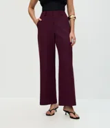 Pantalón de sastrería corte recto, color marrón, con cintura de tiro medio, trabillas largas y bolsillos traseros.
