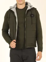 Chaleco verde militar de nylon mate reversible con interior de tejido jogging gris melange, con capucha y cierre frontal con cremallera.