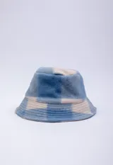 Gorro tipo bucket de textura peluda, con estampado a cuadros en tonos azules y beige.
