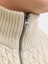 Sweater tejido de punto con diseño de ochos, color beige, con cuello alto y cierre frontal parcial.