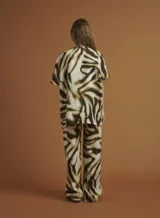 Chaqueta tipo kimono con estampado animal print de cebra en tonos marrón y negro. Tiene mangas 3/4 con bolsillos de parche y está confeccionada en lino.