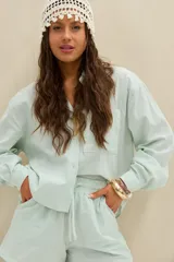 Camisa de rayas celestes y blancas, con cuello clásico, cierre frontal con botones y bolsillo ojal en el pecho.