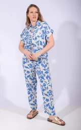 Mono largo color beige con estampado floral azul, de corte recto, con cuello camisero, mangas cortas y cinturón con cordón ajustable.