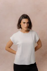 Remera básica color celeste, de corte relajado, cuello redondo y mangas cortas con hombro caído y dobladillo.