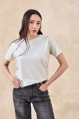 Remerón de manga corta, cuello redondo y calce oversize, en tejido de punto con brillo sutil.