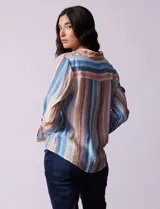 Blusa celeste con estampado de flores grises, de gasa, con cuello con solapa y escote en V, abertura central con botones, bolsillo aplicado y terminación anudada.