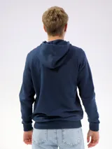 Campera deportiva unisex color beige, confeccionada en algodón con felpa, con capucha, cierre frontal y bolsillo tipo canguro.