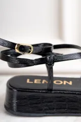 Sandalias negras de cuero charol con plataforma y tiras finas cruzadas.