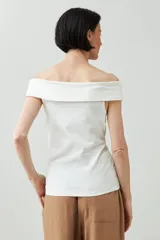 Remera de color marrón con escote bardot, diseño ajustado al cuerpo y mangas cortas.