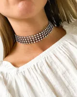 Gargantilla choker negra con tres hileras de strass blancos.
