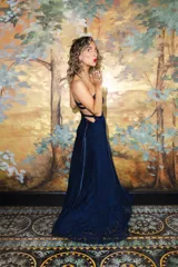 Vestido largo strapless de encaje negro con transparencias y espalda descubierta con tiras cruzadas, de corte entallado y falda de caída suelta.