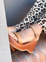 Sandalias de cuero color marrón con plataforma y pulsera al tobillo.