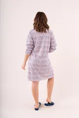 Camisón corto de manga larga con estampado floral en tonos coral, azul y blanco. Tiene cuello en V con detalle de puntilla blanca y cierre de botones en el pecho.