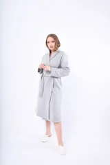 Bata gris de media estación con textura labrada, mangas largas y lazo para ajustar en la cintura.