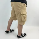 Bermuda de jean color beige con lavado gastado, corte recto y bolsillos cargo laterales.