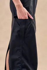 Falda midi negra estilo parachute, con cintura elástica, bolsillos laterales tipo cargo y cordones ajustables en el ruedo.