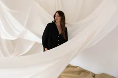 Camisa negra de manga larga con botones blancos y cuello en V.