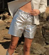 Short de cuero plateado con acabado metalizado y efecto arrugado, corte estilo jean de tiro medio y largo por encima de la rodilla.