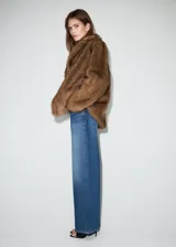 Jeans de tiro medio con diseño wide leg, cintura cruzada y cierre frontal asimétrico con cremallera y botones. Cuenta con cinco bolsillos y presillas para cinto.