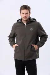 Campera repelente al agua y cortaviento de color negro, con capucha desmontable, cierre frontal y parche circular en el pecho.