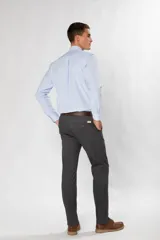 Pantalón de gabardina color marrón claro, corte slim fit, con bolsillos laterales y traseros. Se ajusta a la cintura con cinturón de cuero marrón.