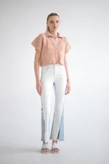 Sweater tejido de punto color rosa, con cuello polo, mangas cortas con detalle de calado y diseño geométrico en la parte inferior.