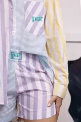 Shorts patchwork con estampado a rayas en tonos pastel (lila, amarillo, celeste y blanco) y detalle de bordado con la palabra 'pur' en verde.