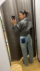 Pantalón de jean celeste con estampado de cuadrados plateados reflectantes.